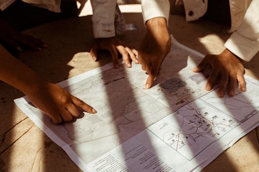 Group of hands pointing at a detailed map, planning trip